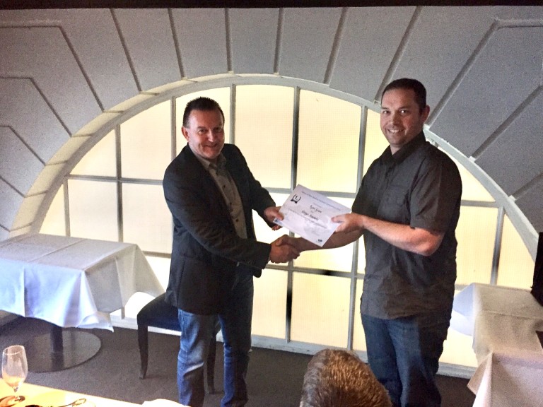 Winger Subaru Pukekohe service technician Ryan Grave receiving congratulations from Subaru of New Zealand Managing Director Wallis Dumper.